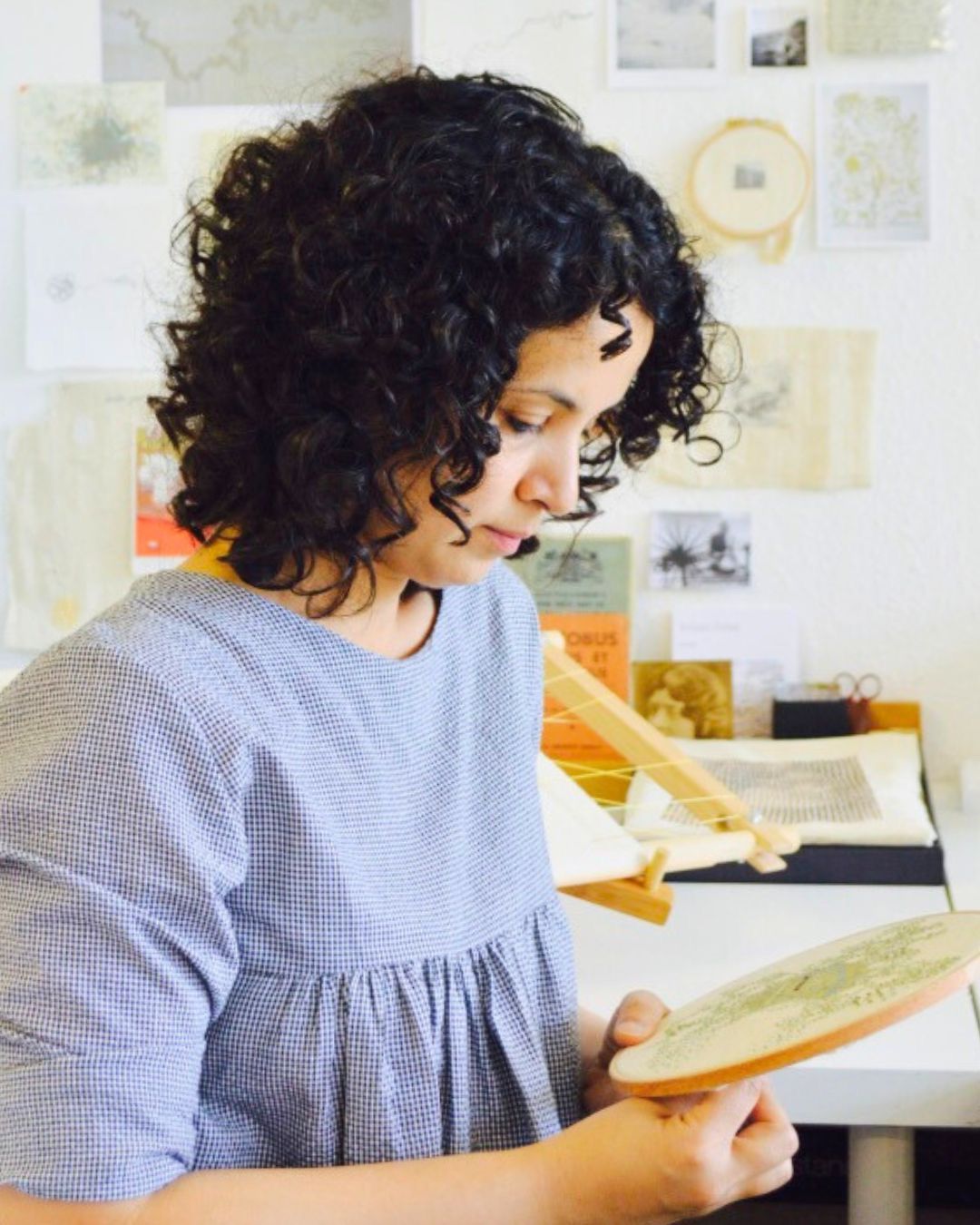 A female artist stitching in her studio