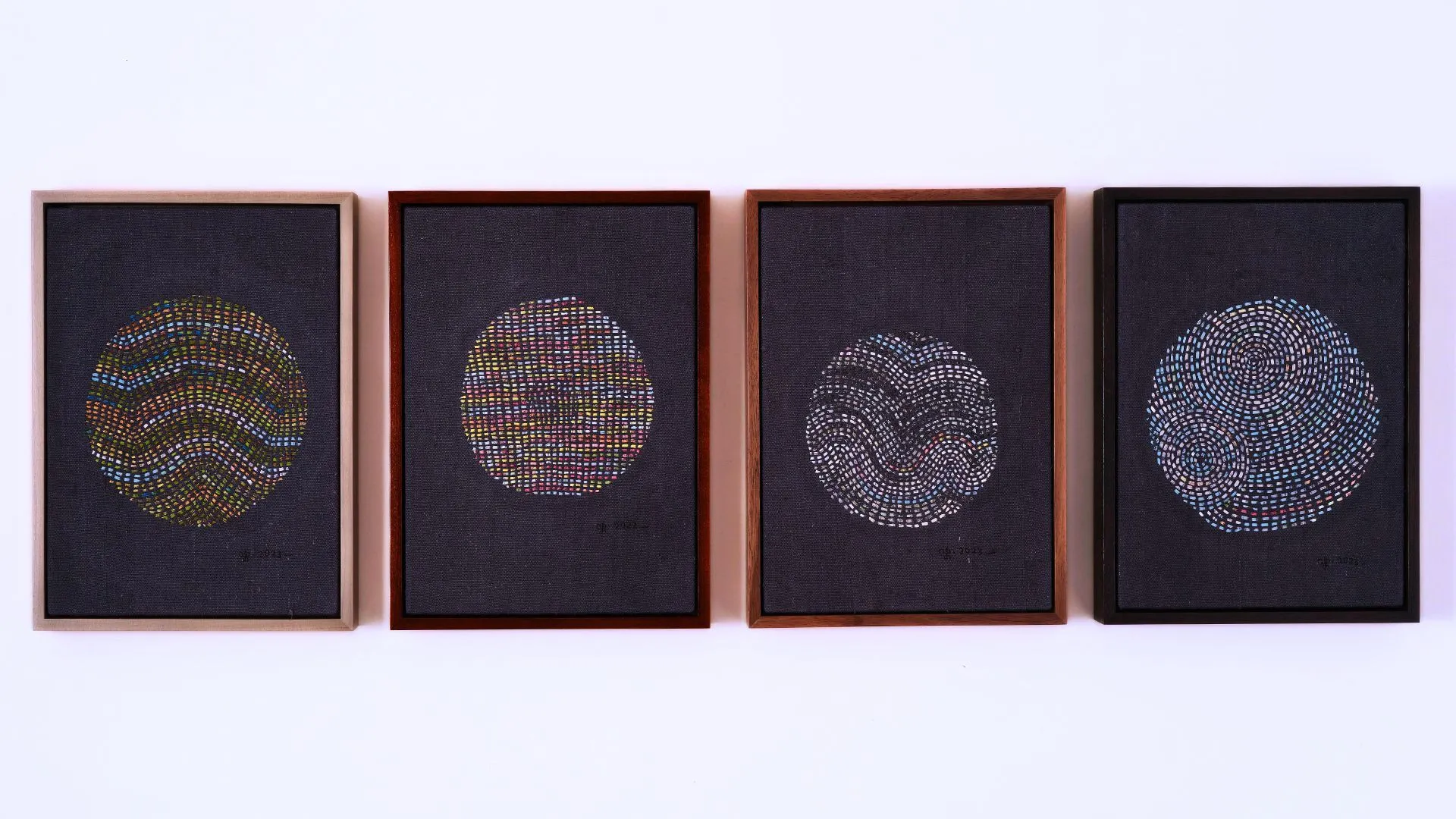 A group of framed hand stitched artworks depicting planets