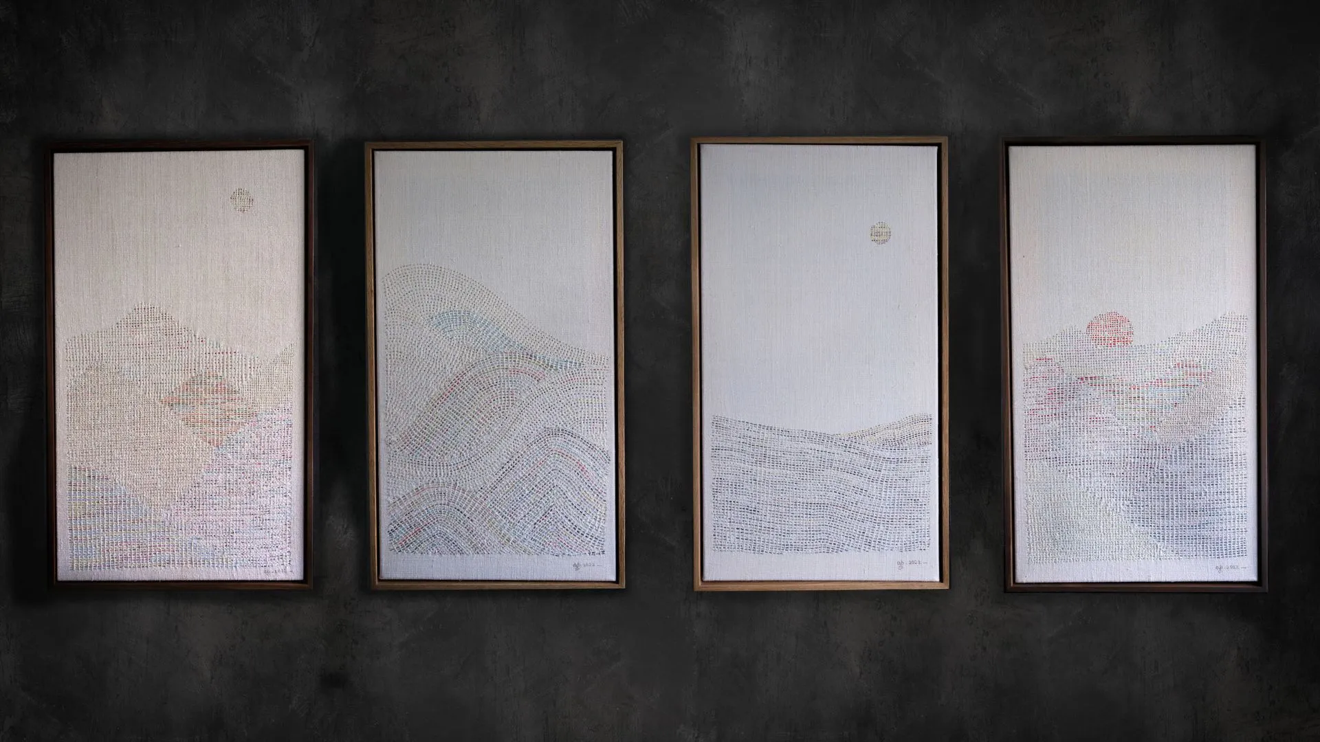 A group of framed hand stitched artworks on a wall