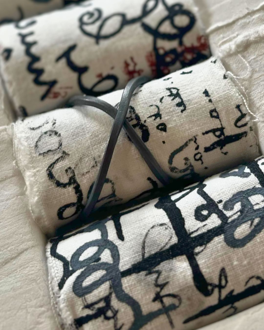 A close up of rolls of fabric bundles with writing on them. 