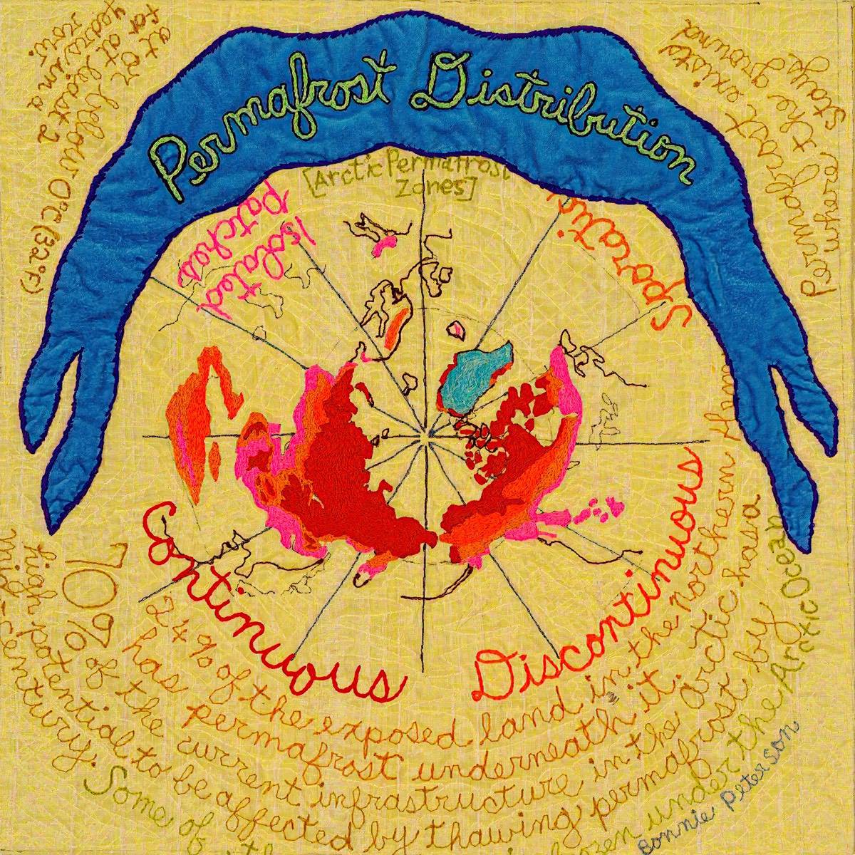 A yellow and red art quilt with a stitched the map of the world across the surface and blue banner with the words 'Permafrost Distribution' on it