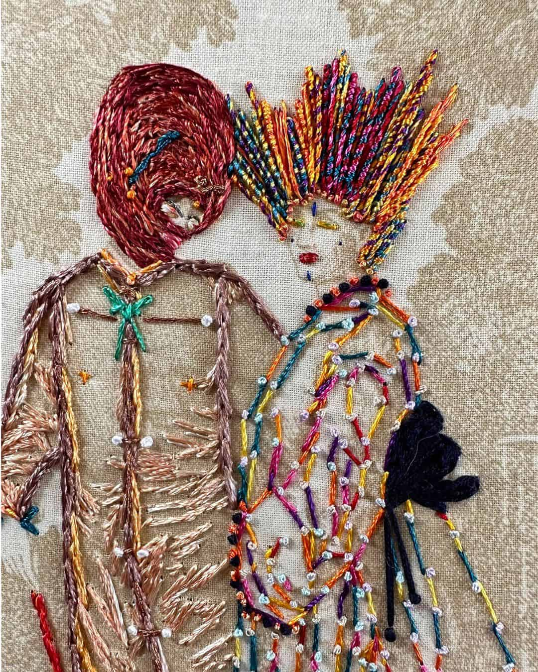 a close up of an embroidery of two people in fine clothes