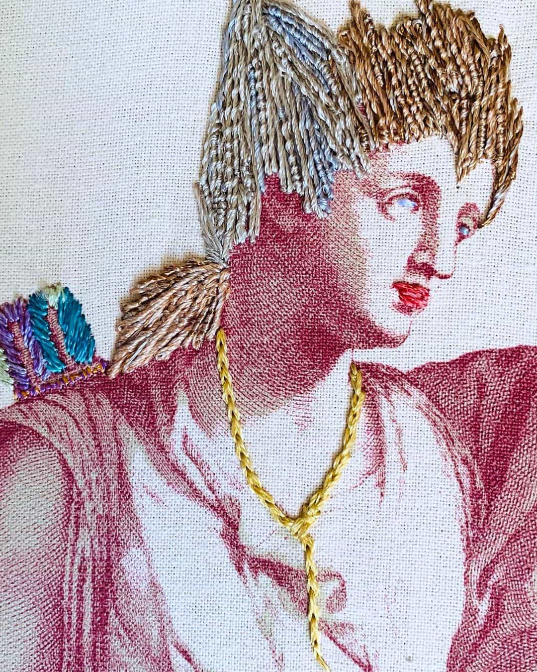 a close up of a printed image of a person with hand-stitched hair lips and a necklace.