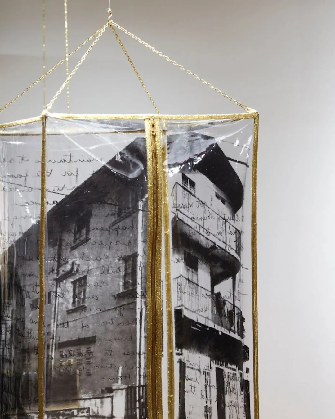 An art installation with gold lined transparent case and screen printed building inside