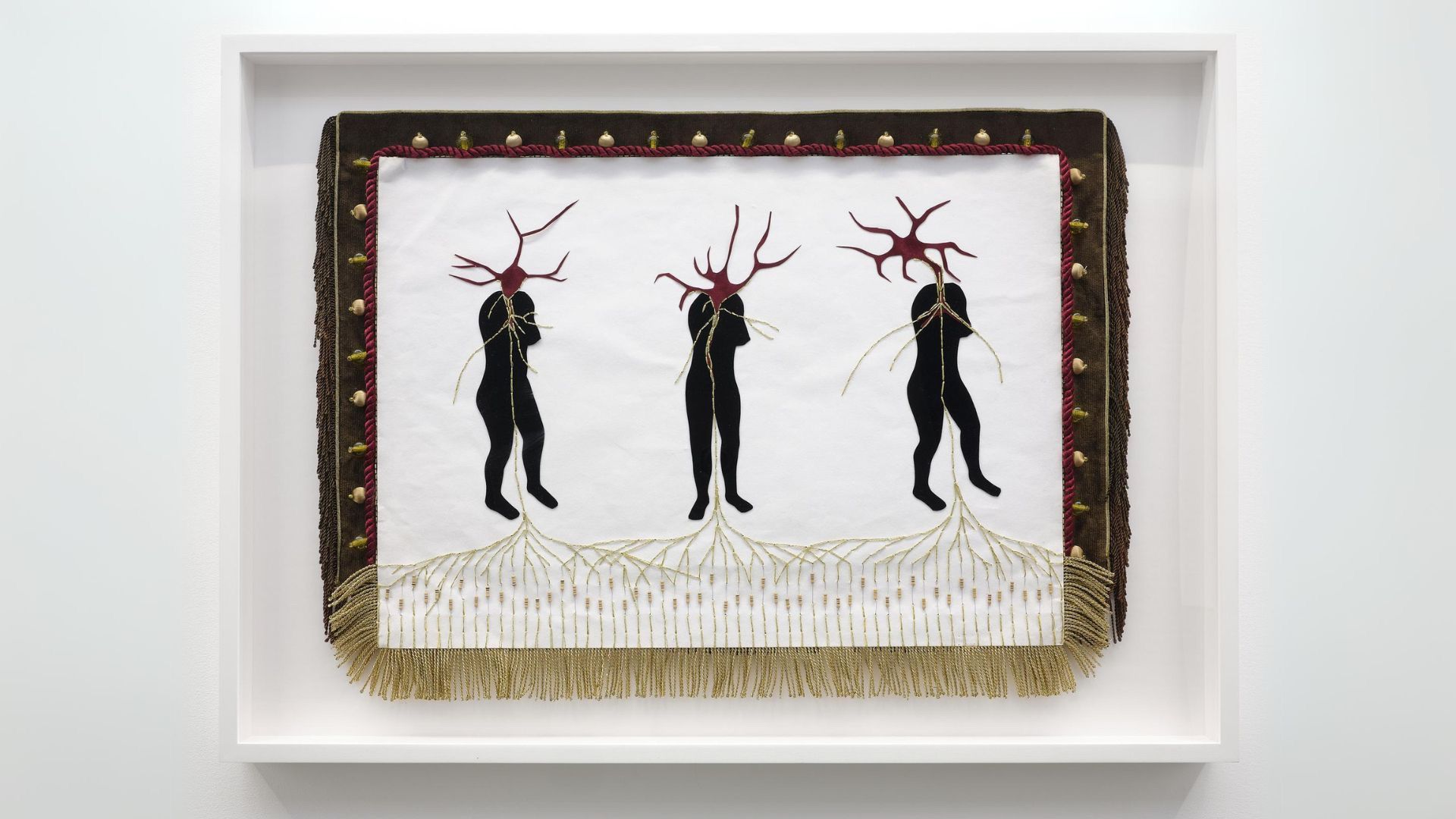 A piece of textile art hung on a white gallery wall