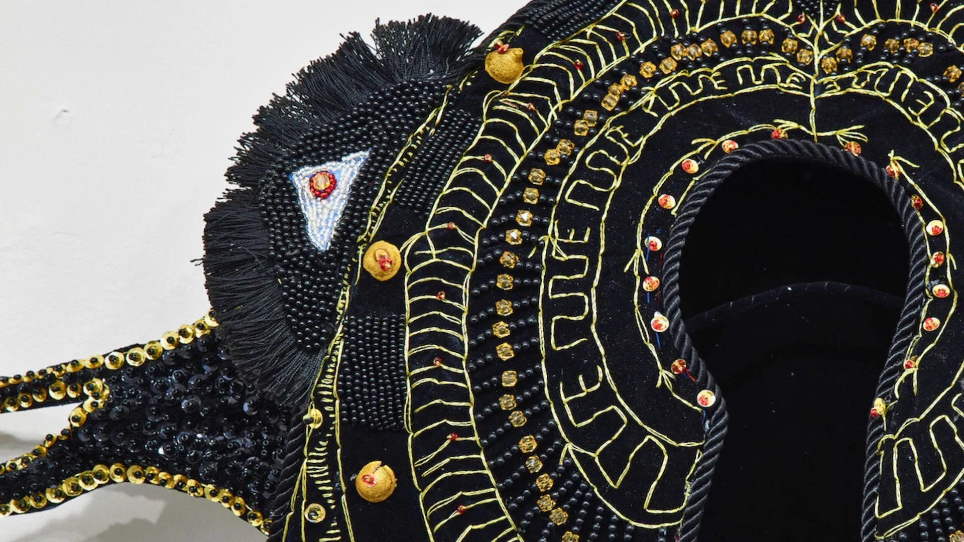 A closeup of a black and gold beaded sculpture