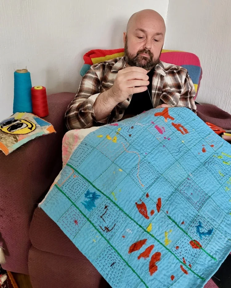 Anthony Stevens stitching one of his artworks at home.