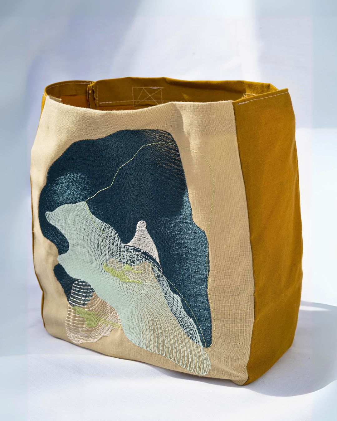 a fabric bag, artwork with an embroidered exterior