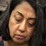 A close up image of textile artist Amarjeet K. Nandhra working in her studio.