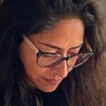 A close-up image of textile artist Andrea Barrios Aguilar in her studio, working on a textile design.