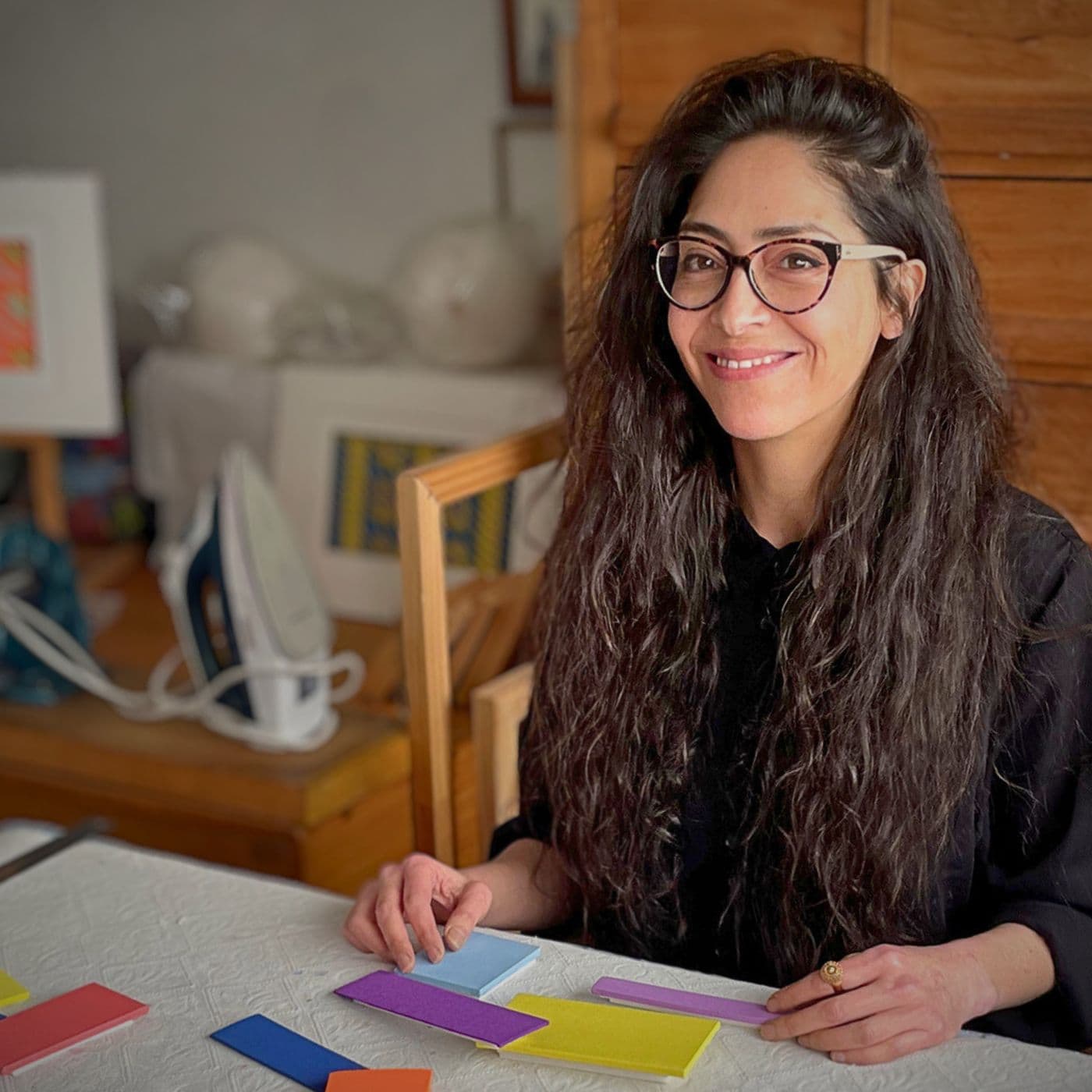 Andrea Barrios Aguilar in her studio, smiling at the camera.