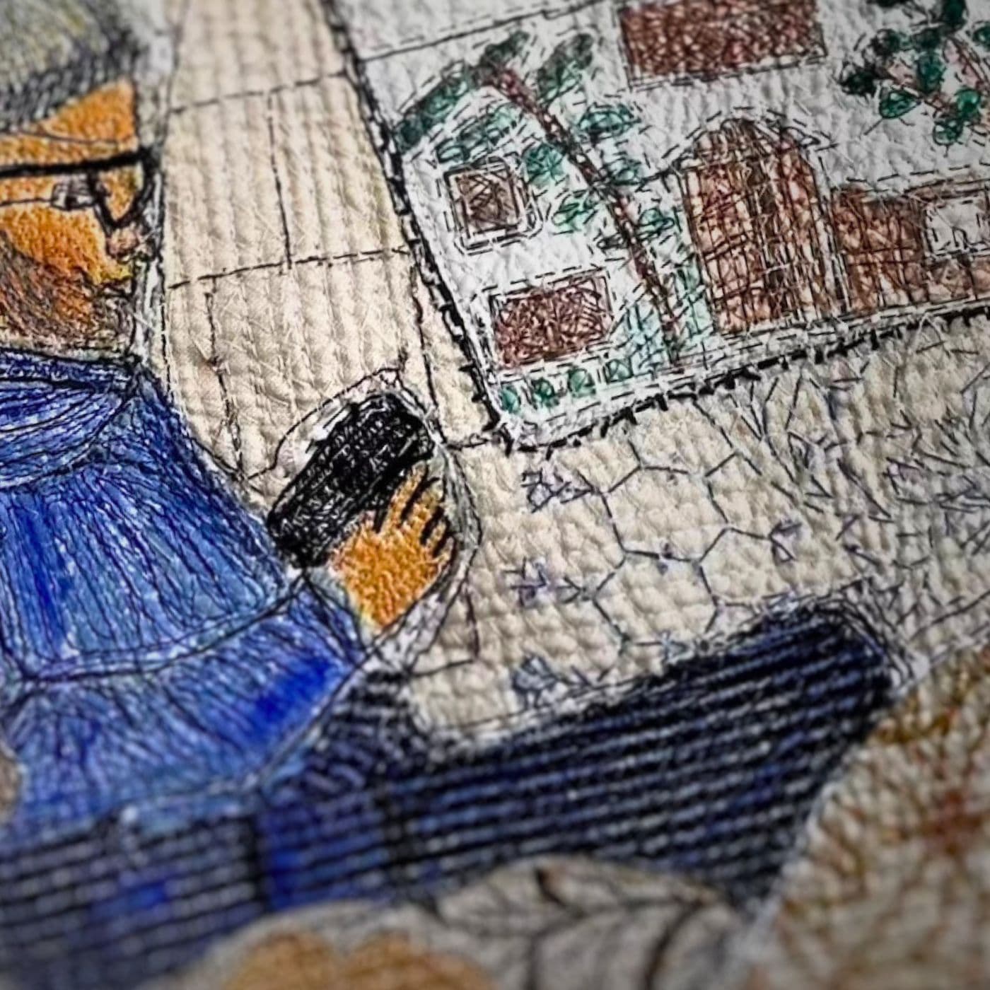 A close up of a stitched artwork of a man sitting.