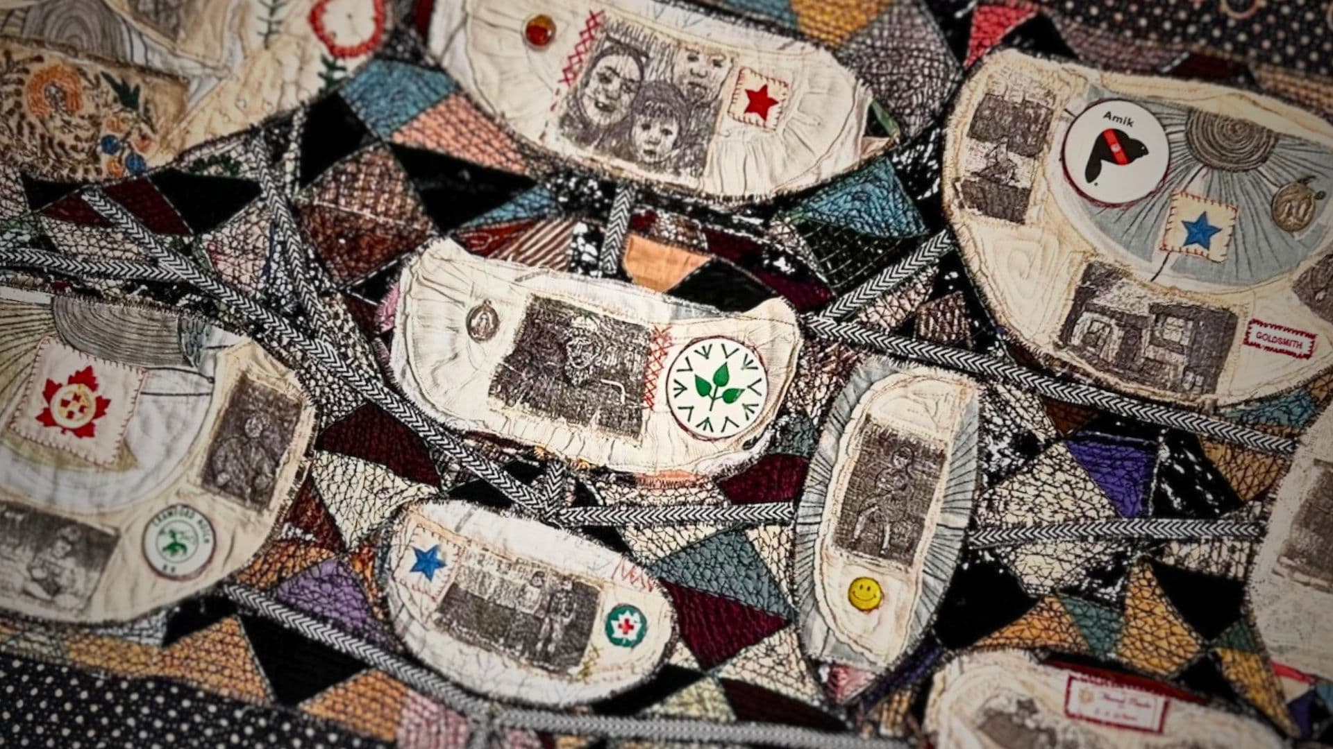 A close up of an abstract stitched artwork using recycled collars with images of peoples faces within.