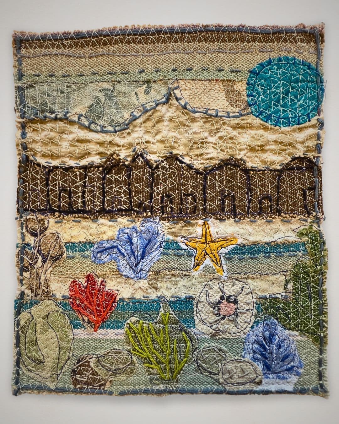 A stitched artwork of with a beach scene.