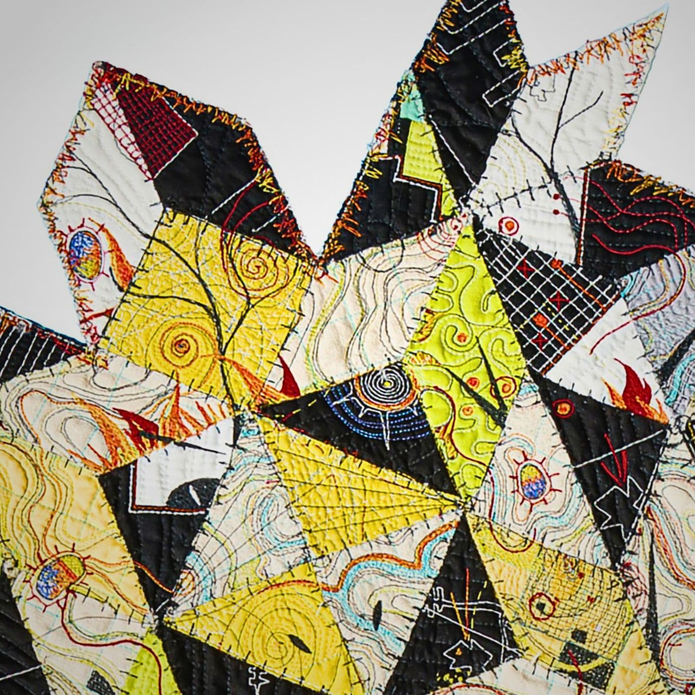 A section of a patchwork art quilt on a white surface