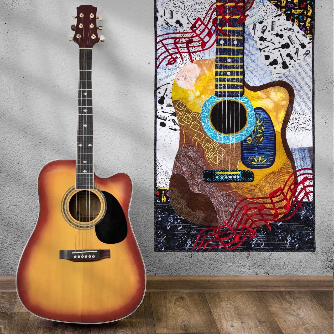 A guitar next to a quilted artwork of a guitar