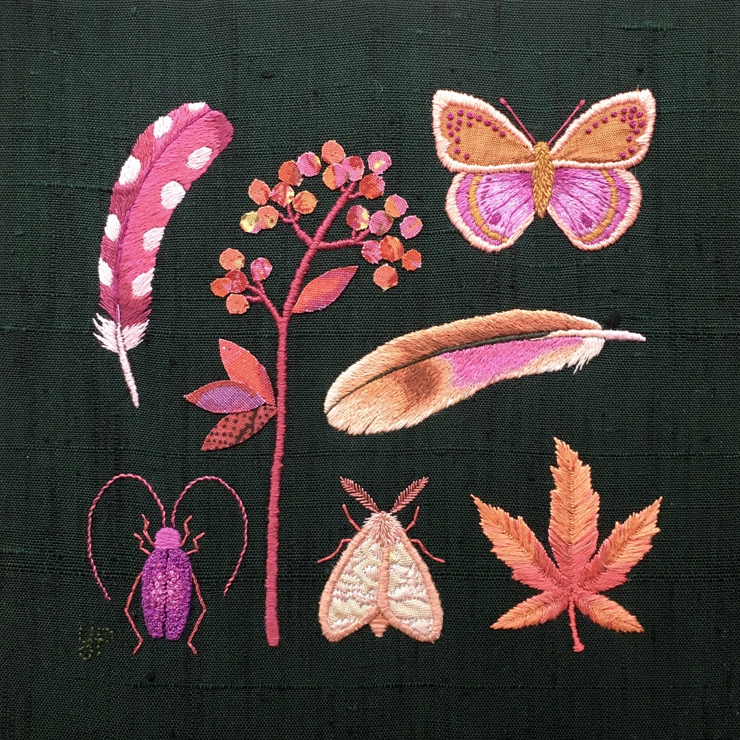 a group of butterflies and flowers embroidered on fabric