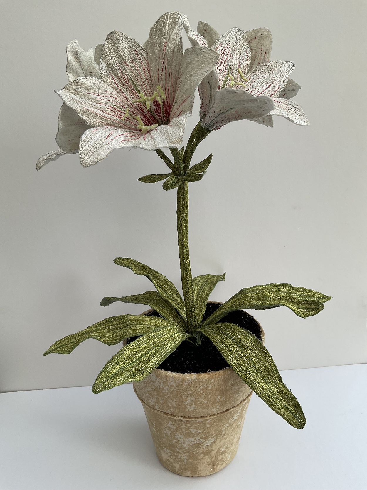 Corinne Young, Amaryllis Pot Plant at Bonadea, London, 2021. 40cm (16”)  tall. Machine stitch. Madeira threads, net, textile medium, florist’s wire/tape and flax fibres. 