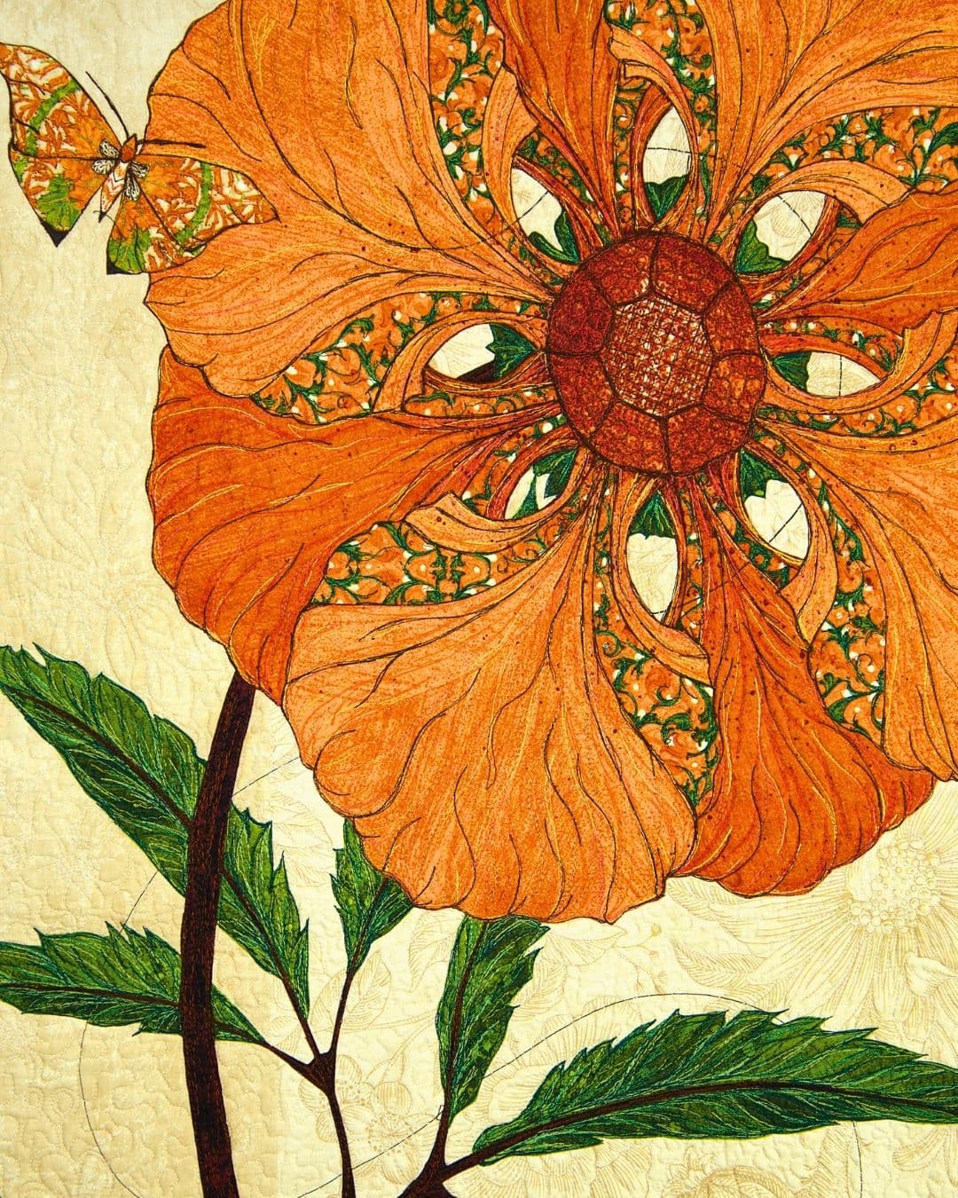 A close up of a stitched and quilted artwork of a yellow flower