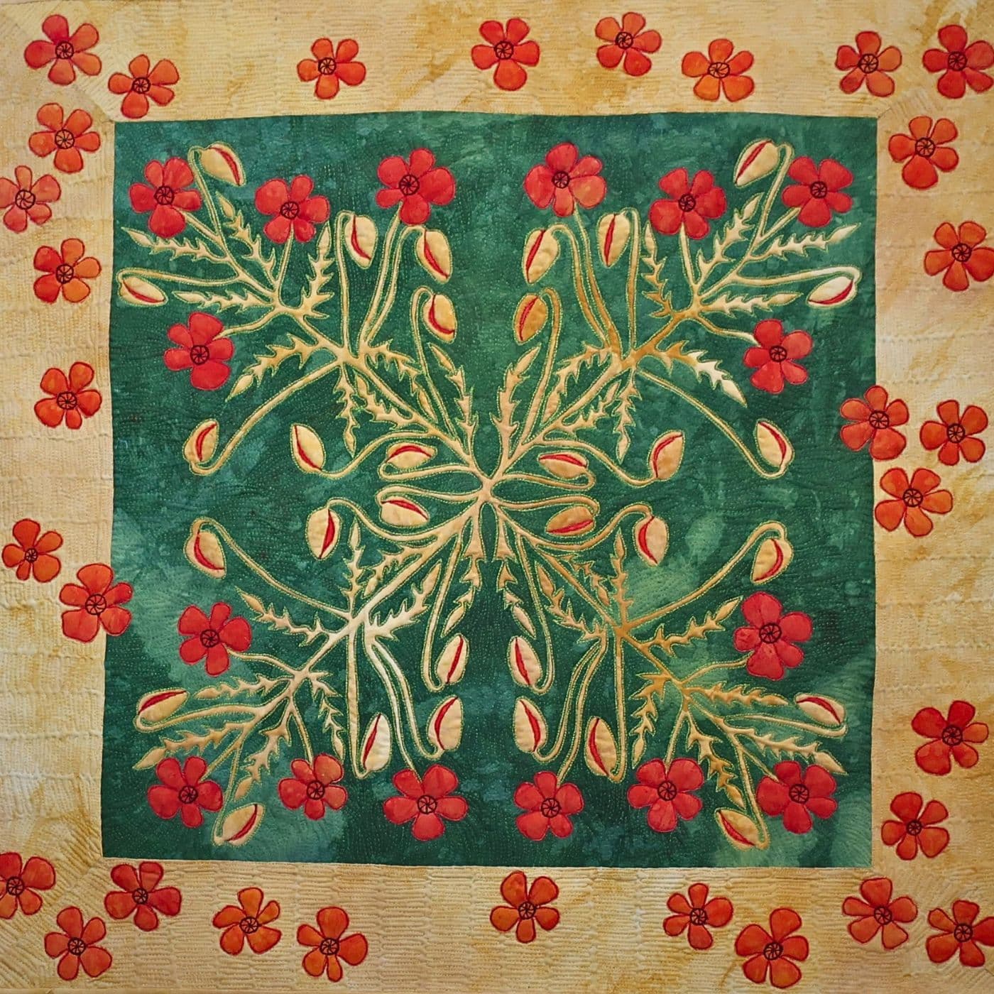 A stitched art quilt of a cross within a square pattern embellished with flowers.