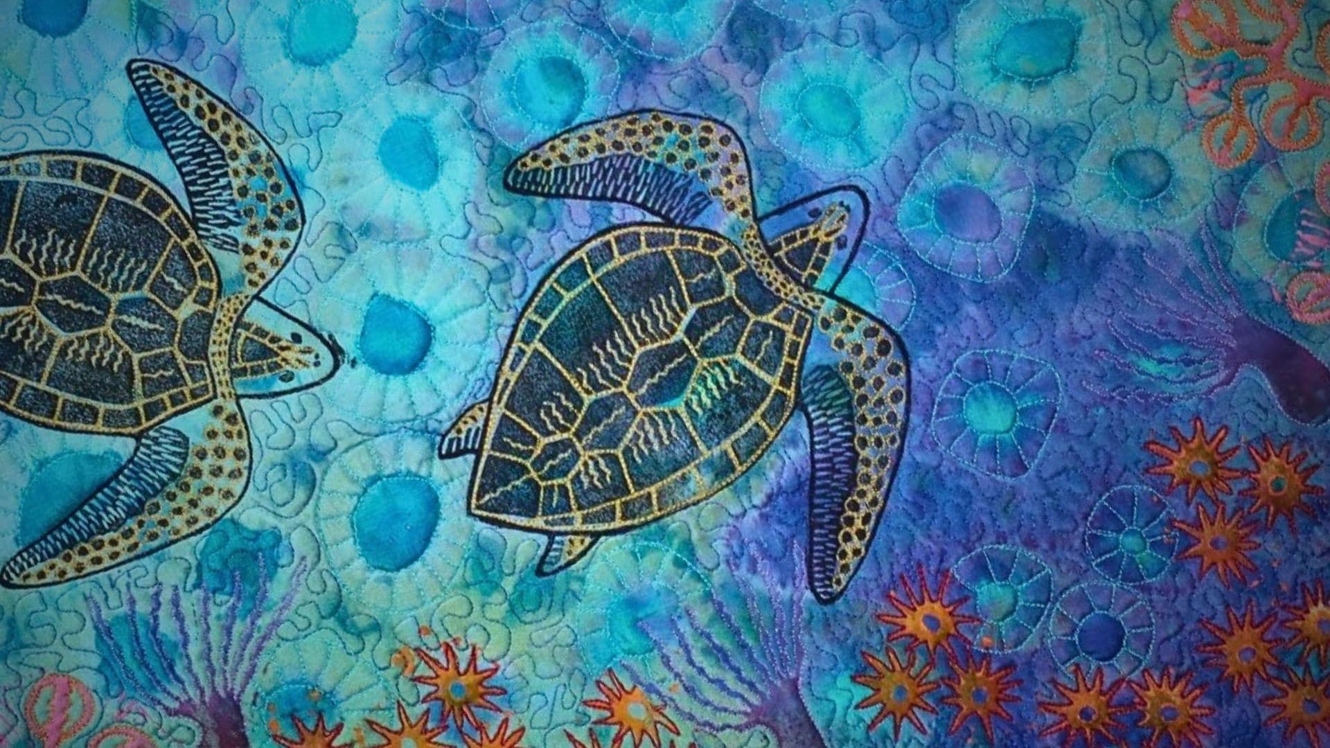 A close up of an art quilt of an underwater scene: turtles swimming in amongst corals. 