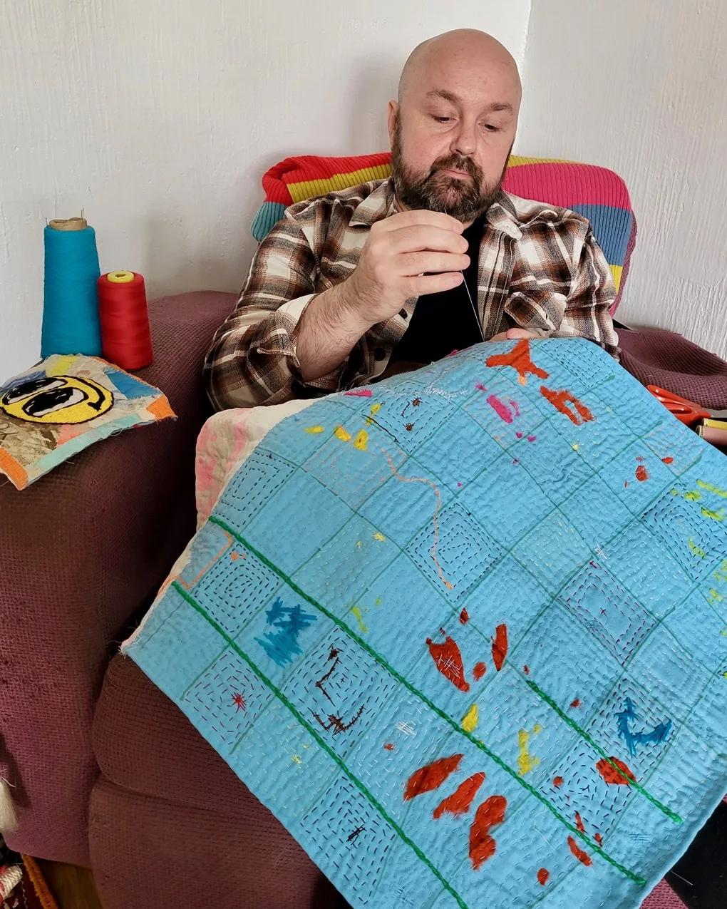 Anthony Stevens stitching one of his artworks at home.