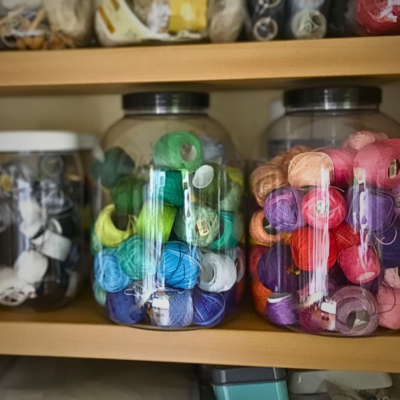 Sweet jars with colourful yarn stored inside. 