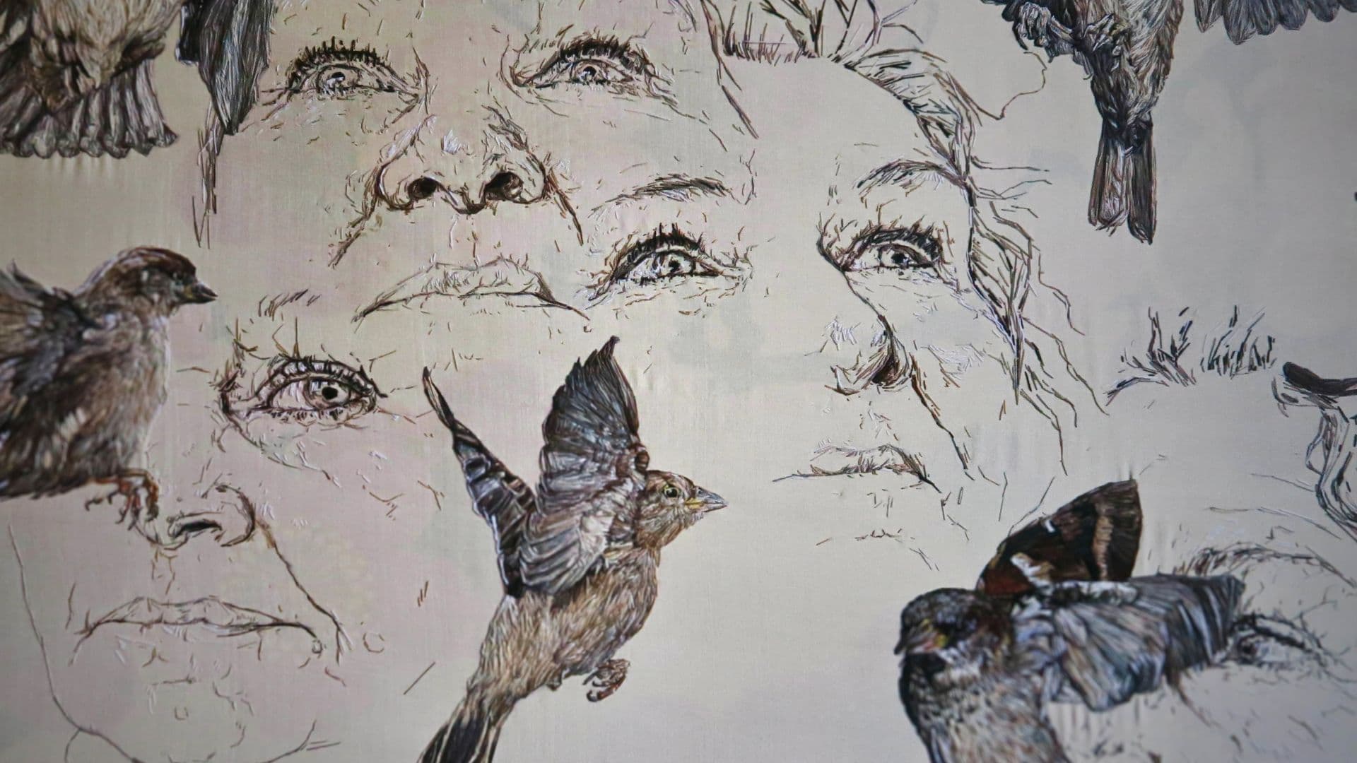 A stitched artwork of a woman's face and birds