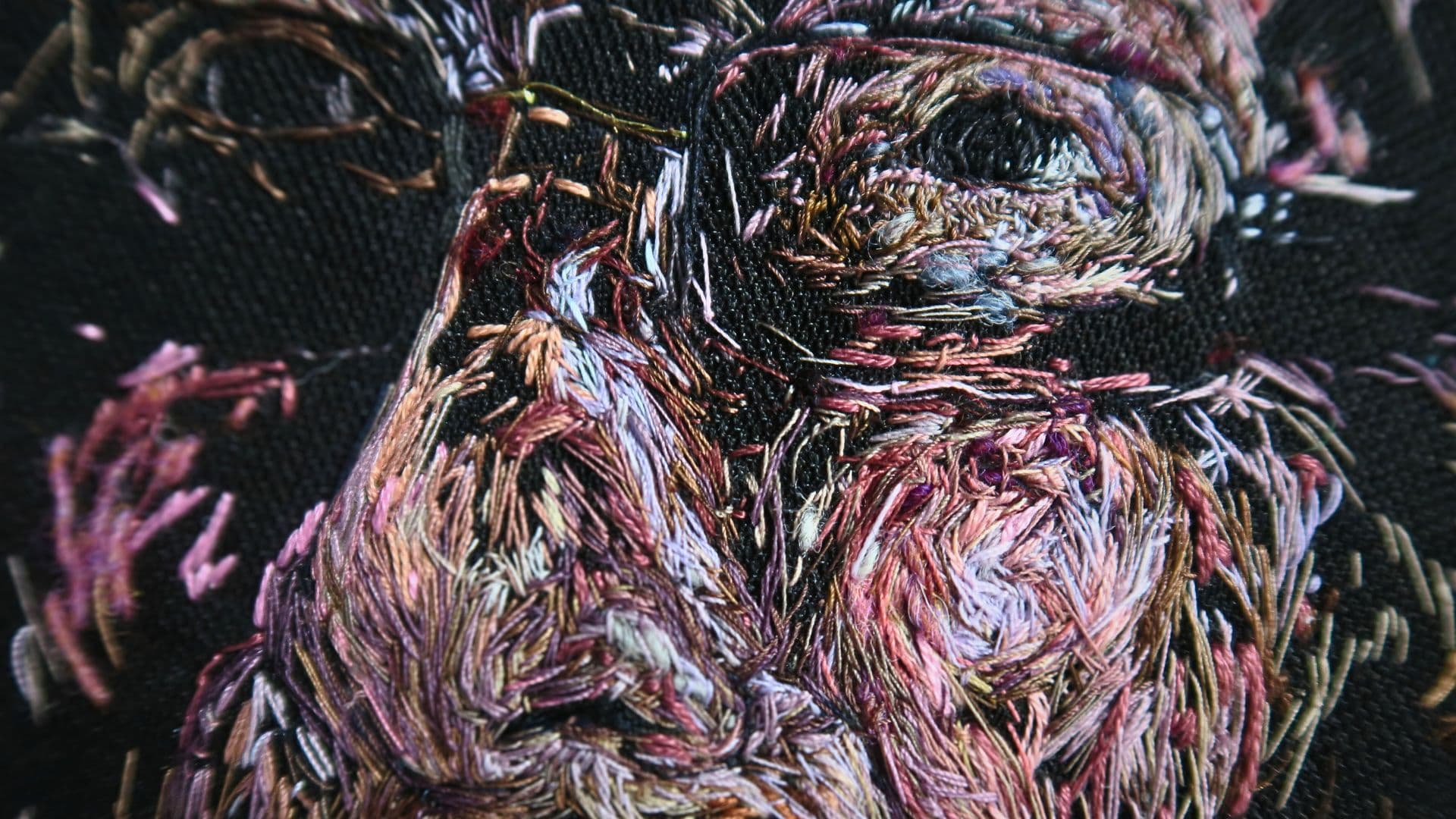 A close up image of a thread painting of a man's face