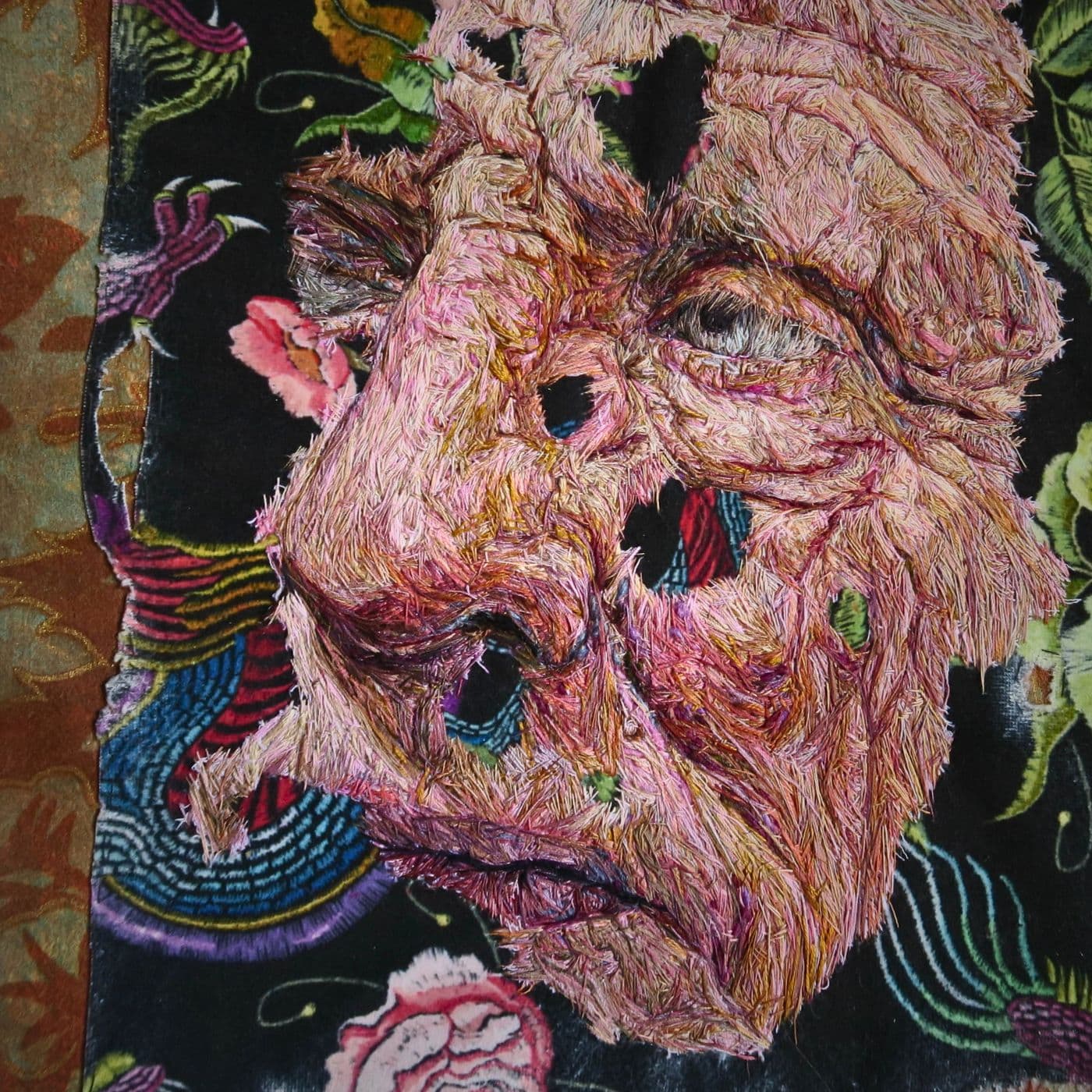 A close up of a thread painting of a face