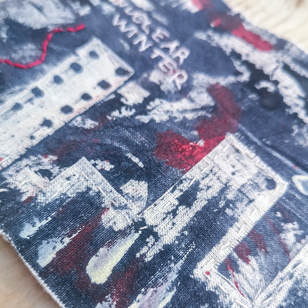 Moyra Costello, Nuclear Winter, 2022. 8cm x 18cm (3" x 7"). Hand stitching, painting on fabric, mark making. Acrylic paint, cotton perlé and stranded embroidery thread, linen thread, calico, vintage quilt pieces.