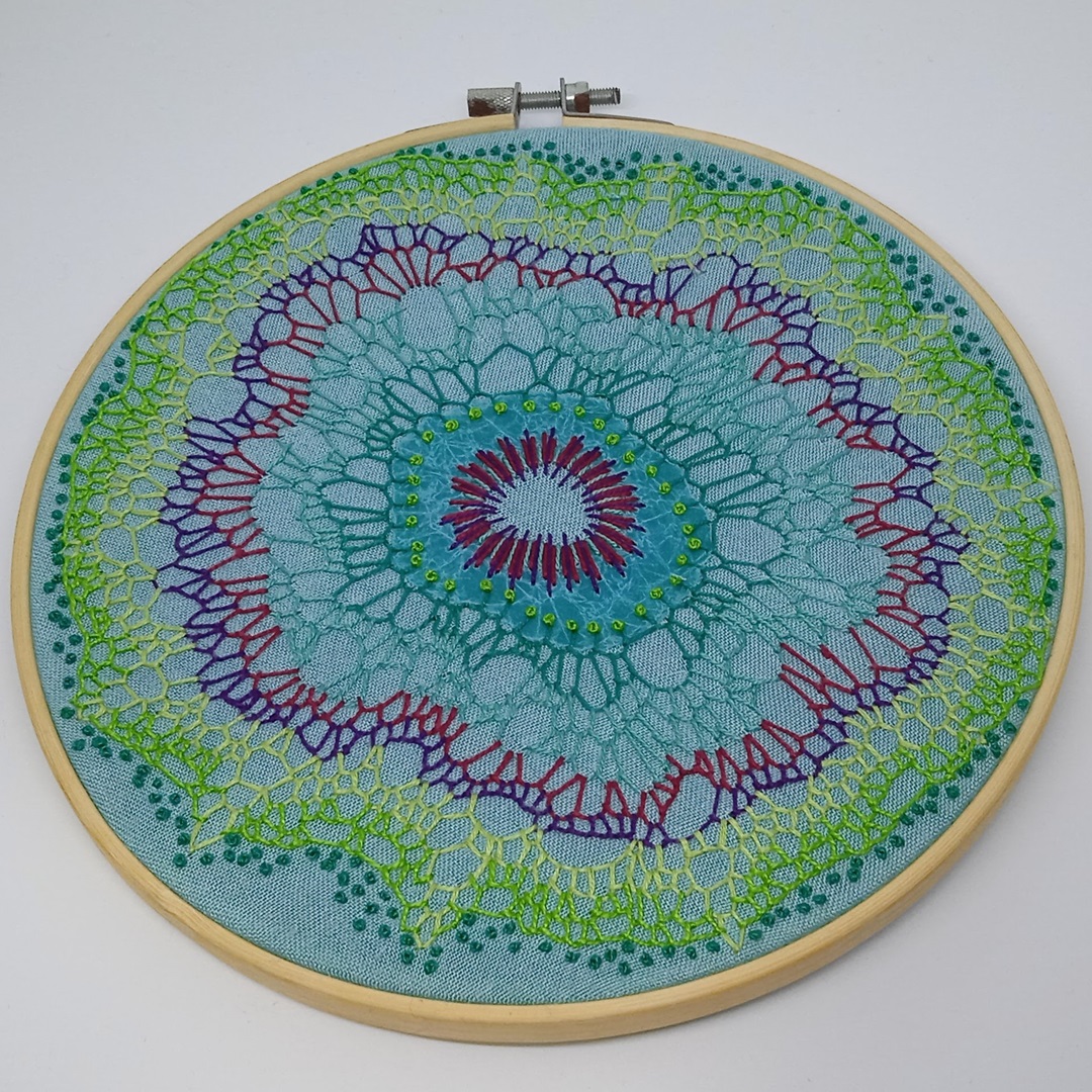 Luza Lema, Organic blanket stitch organism, 2023. 20cm (8") diameter. Appliqué, buttonhole stitch. DMC cotton, perlé and mouliné threads, waxed tissue paper, plain weave cotton fabric.