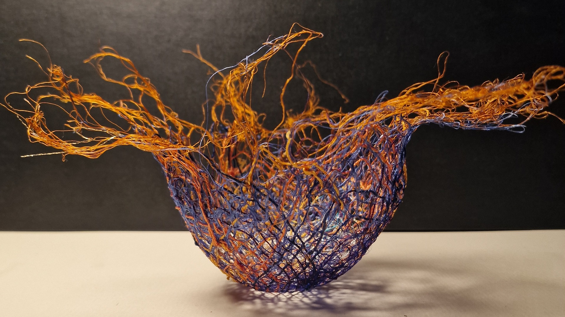 Maggie Rastall, Vessel 1 (2023). 10.5 cm x 20cm (4" x 8"). Hand stitch on water soluble fabric. Throwsters silk waste, fine metallic threads, coloured linen threads.