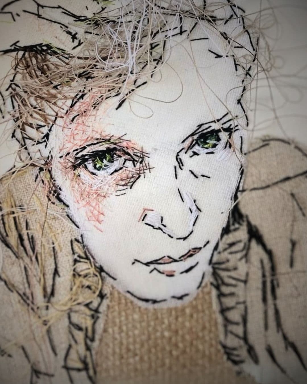 A stitched portrait of a woman's face, staring intensely. 