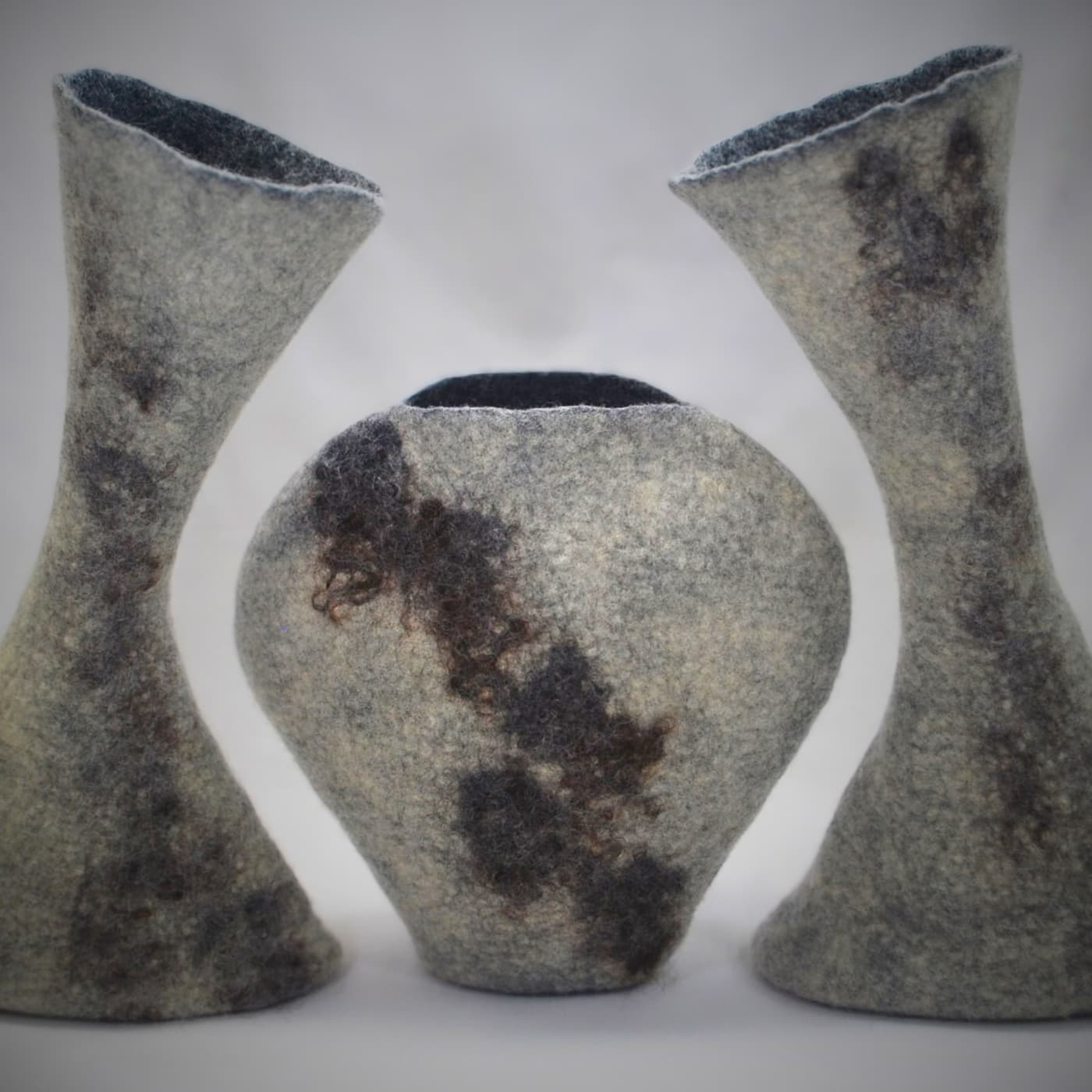 A group of felt vases with a white background