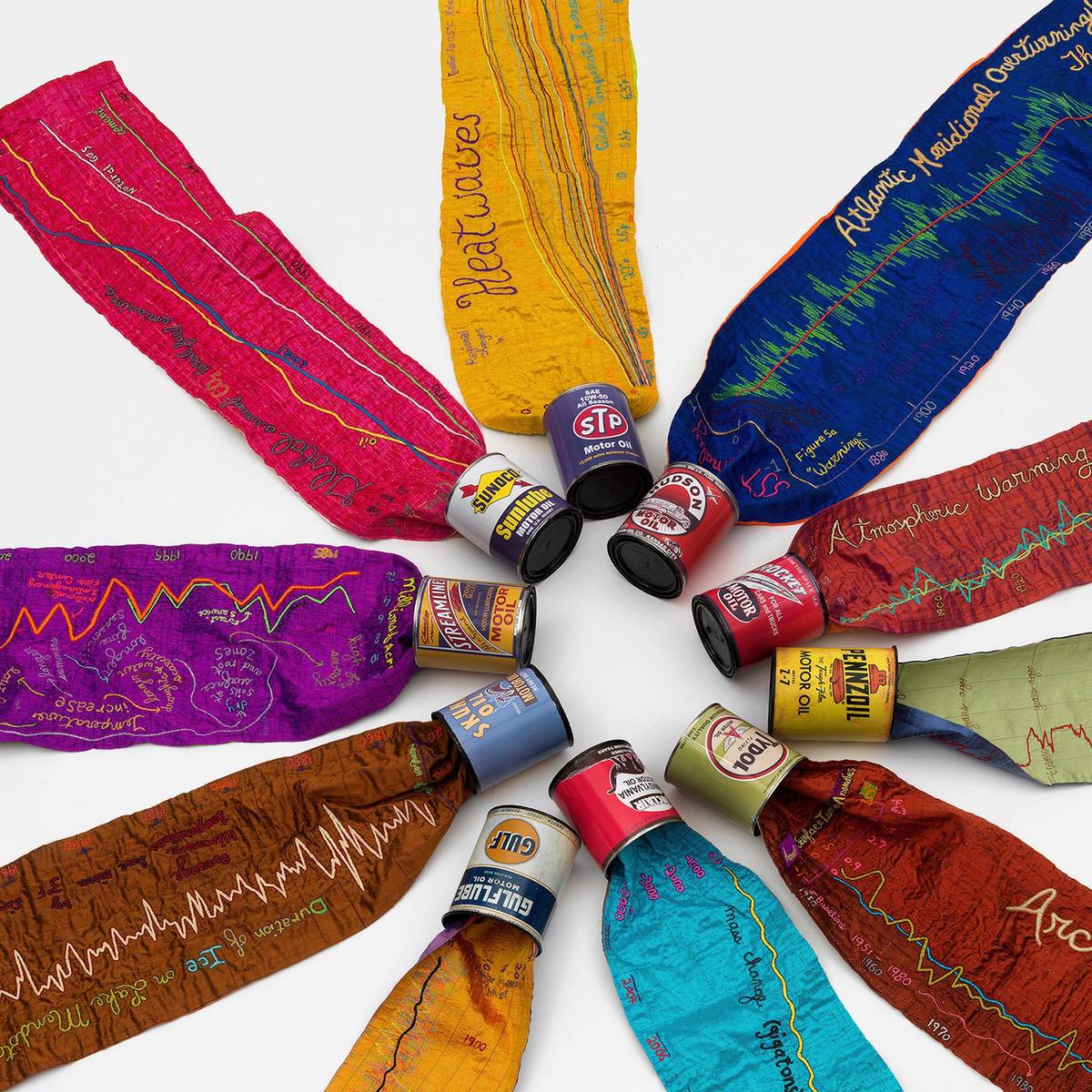 A textile sculpture of colorful ribbons spilling out of different a variety of cans