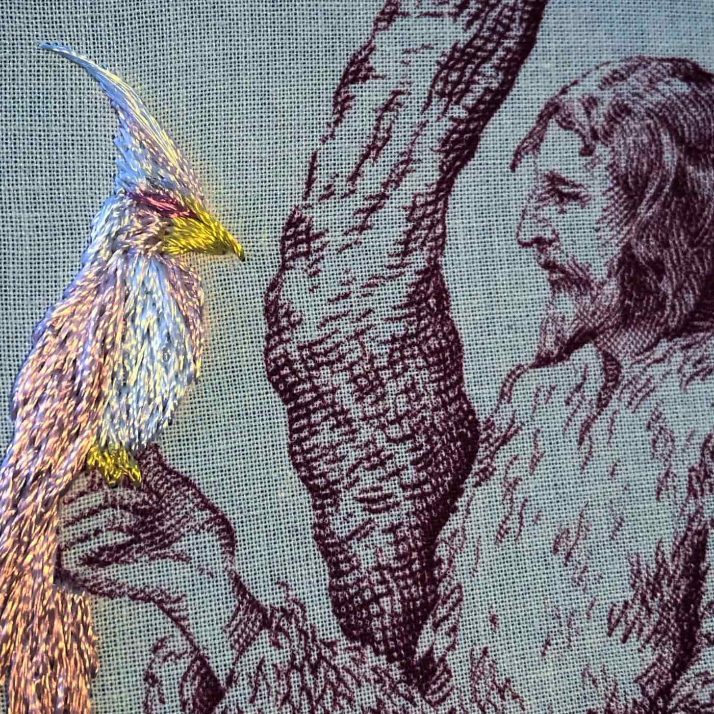 a fabric with a printed image of a man holding a hand-stitched bird