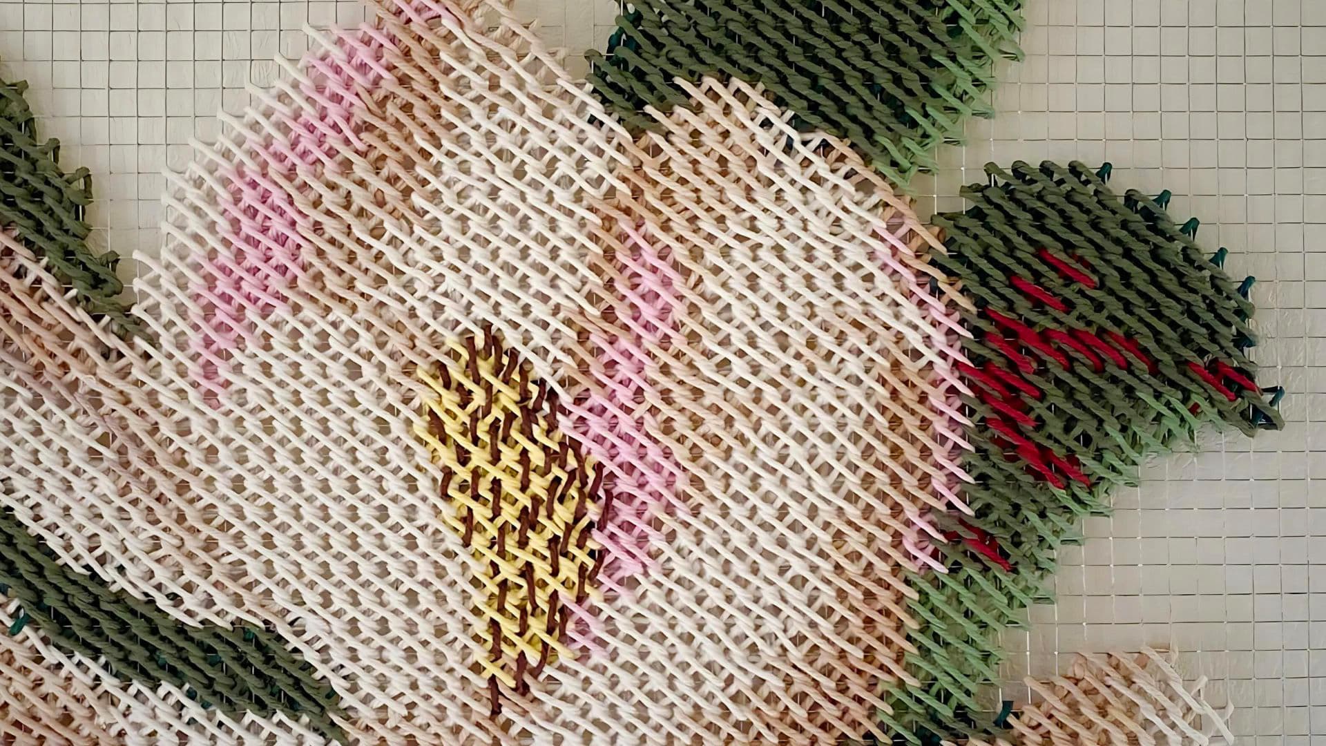 A close up of a stitched, abstract artwork of a magnolia.