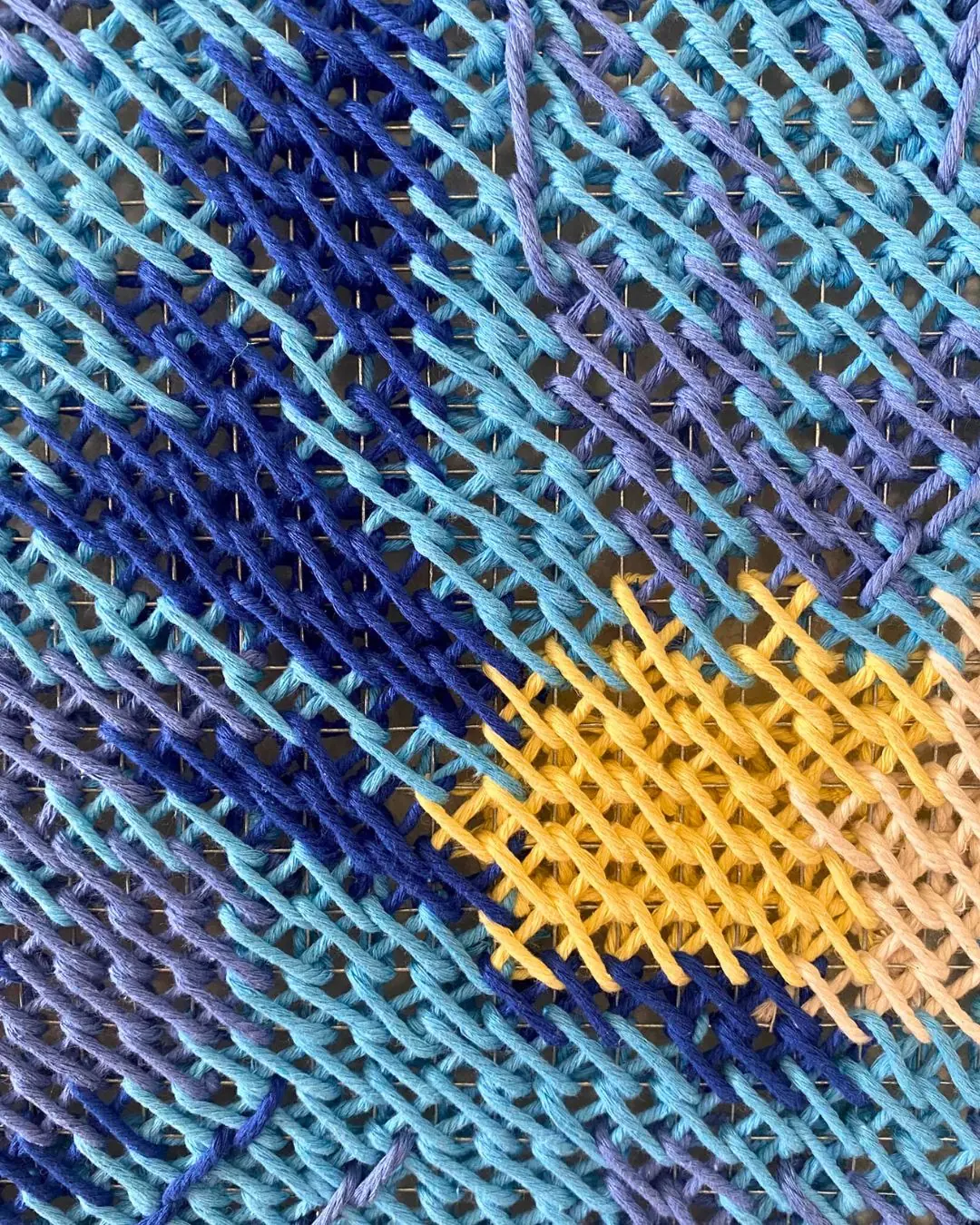 a close up image of a woven fabric artwork.