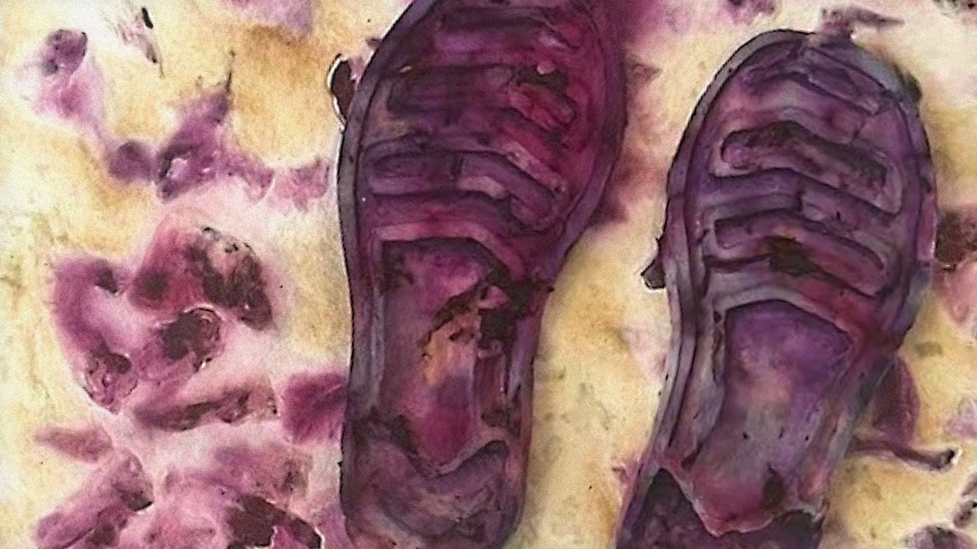 A close-up detail of a pair of purple shoes on an artwork made from paper and cotton