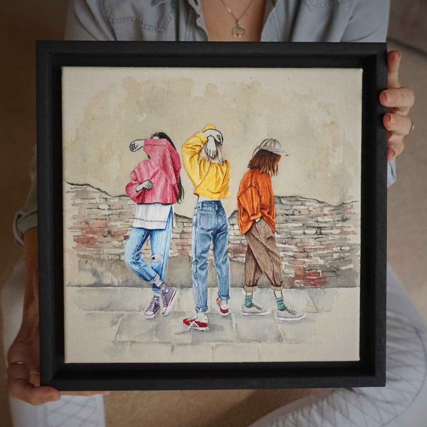 A stitched artwork of three women wearing bright coloured clothes 