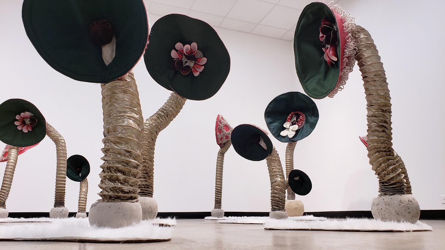 Meghan Rowswell: The Stalks, 2018, 8' x 8' x 5', Rug hooked car upholstery, concrete, spray painted dryer hose, Masonite, faux fur, sewn felt, cotton, velvet. 