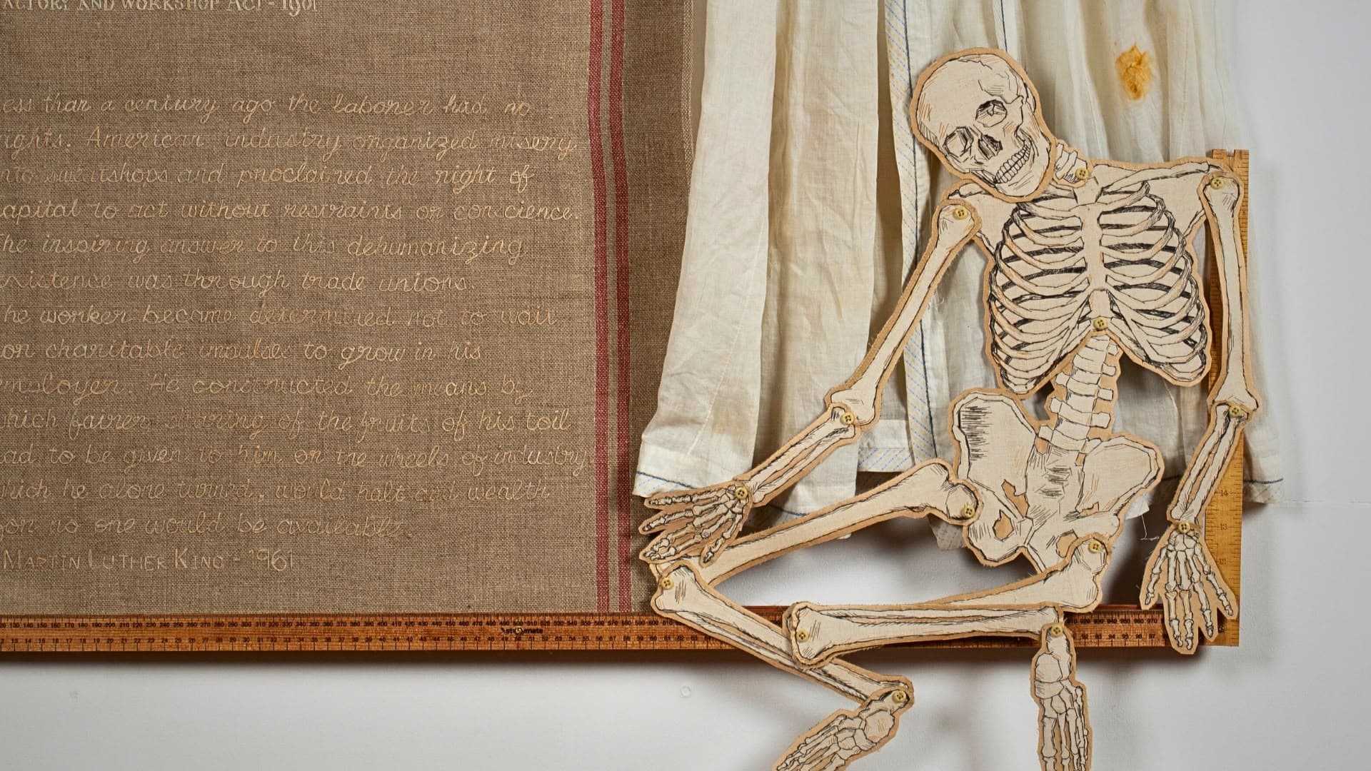 a skeleton cut out of paper next to a piece of fabric