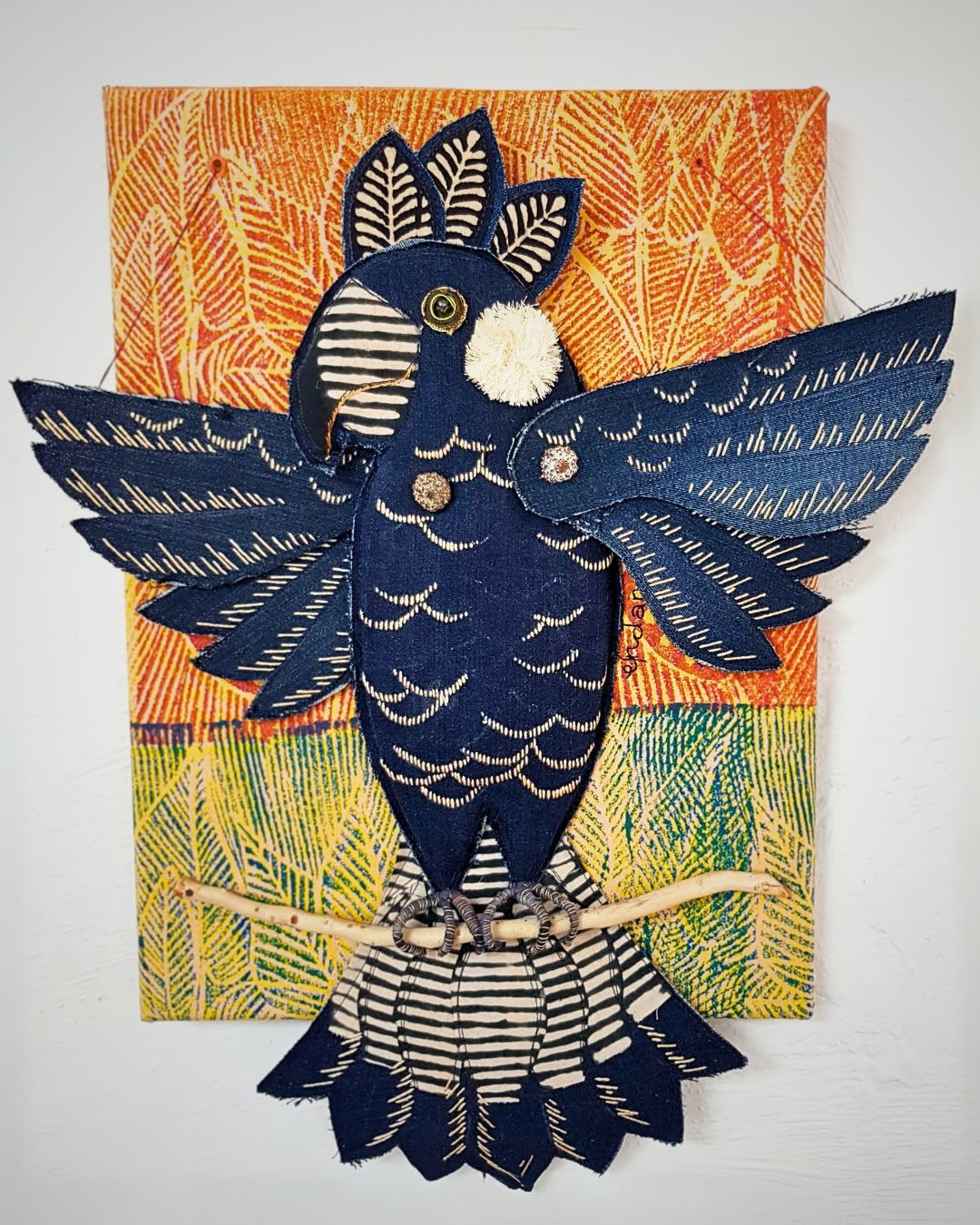 a blue bird made of fabric on a colorful surface