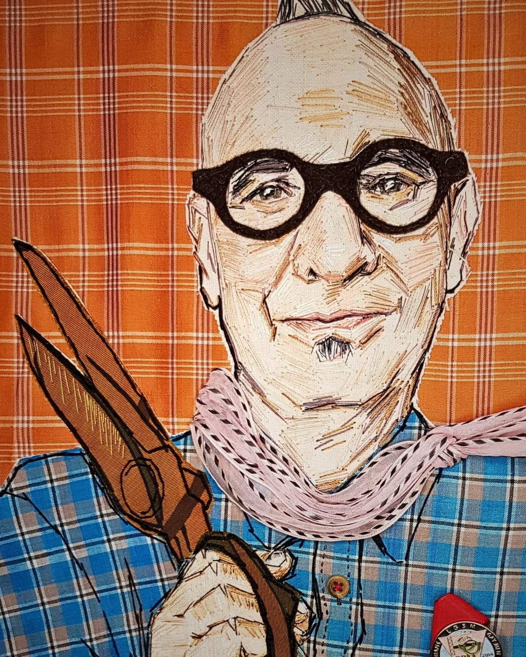 a man with glasses and a scarf holding scissors