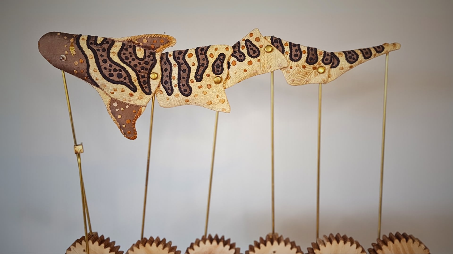 a patterned fish puppet held up by wooden sticks