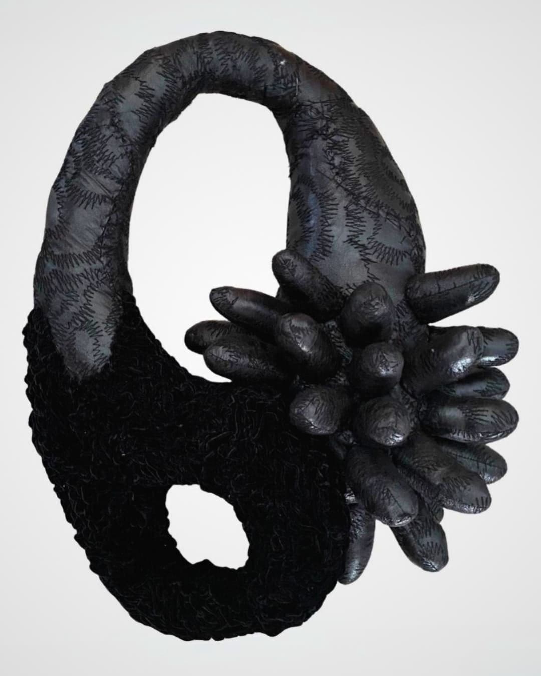 A black sculpture of an abstract cell mutation. 