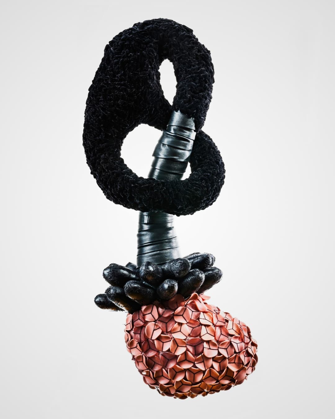 A black and red stitched sculpture hanging in space.