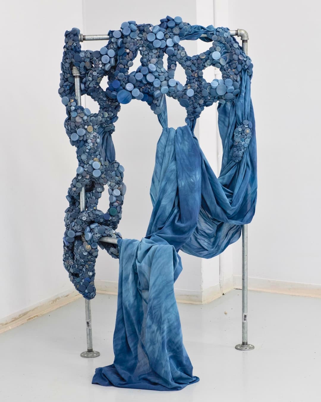 A sculpture of a blue fabric on a metal rack