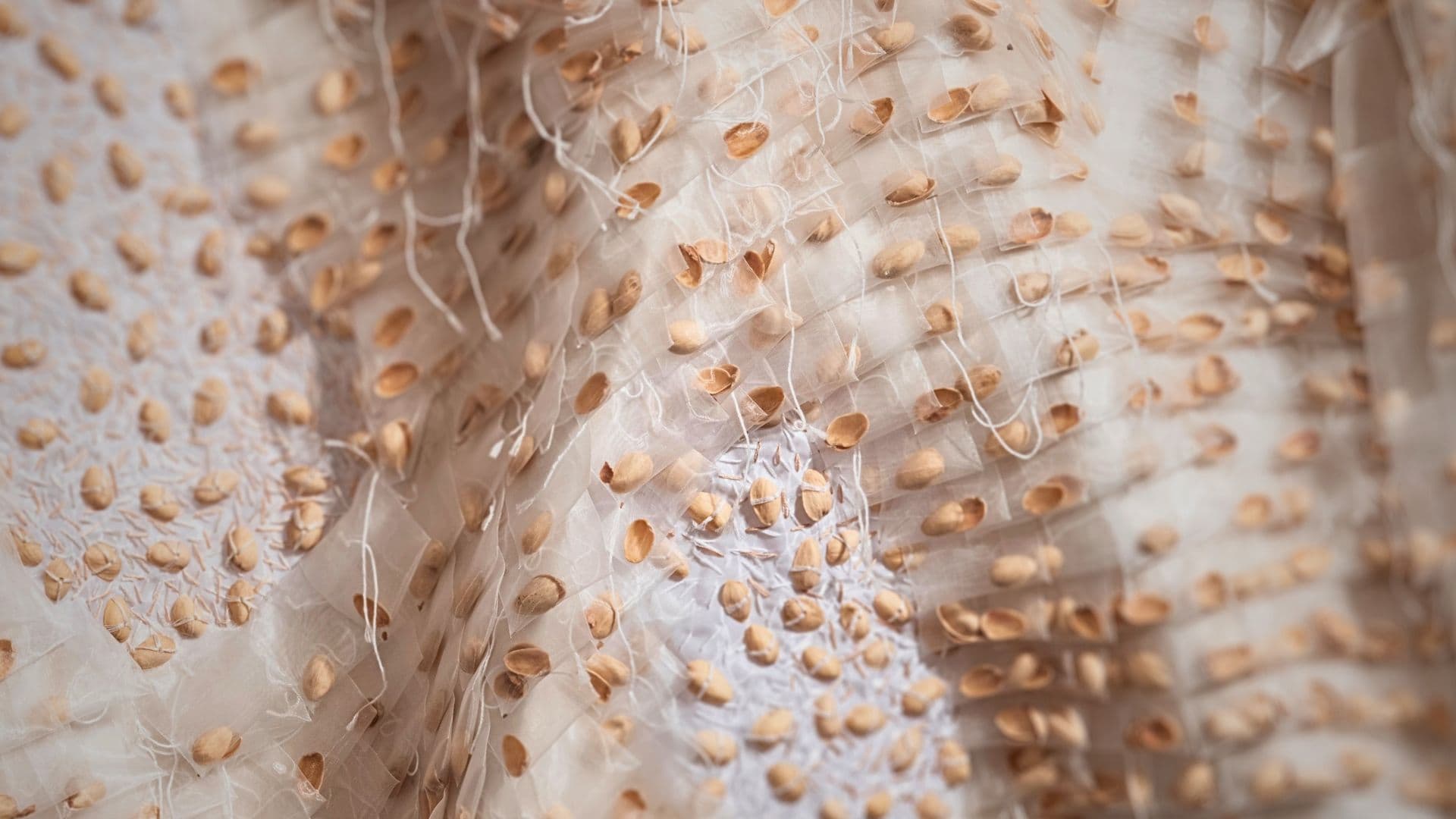 A close up of a cream-coloured textured fabric artwork.